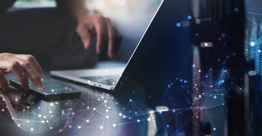 Connectivité Numérique et Innovation Technologique au Travail Main sur smartphone et ordinateur avec graphisme de réseau numérique évoquant la connectivité et la technologie.